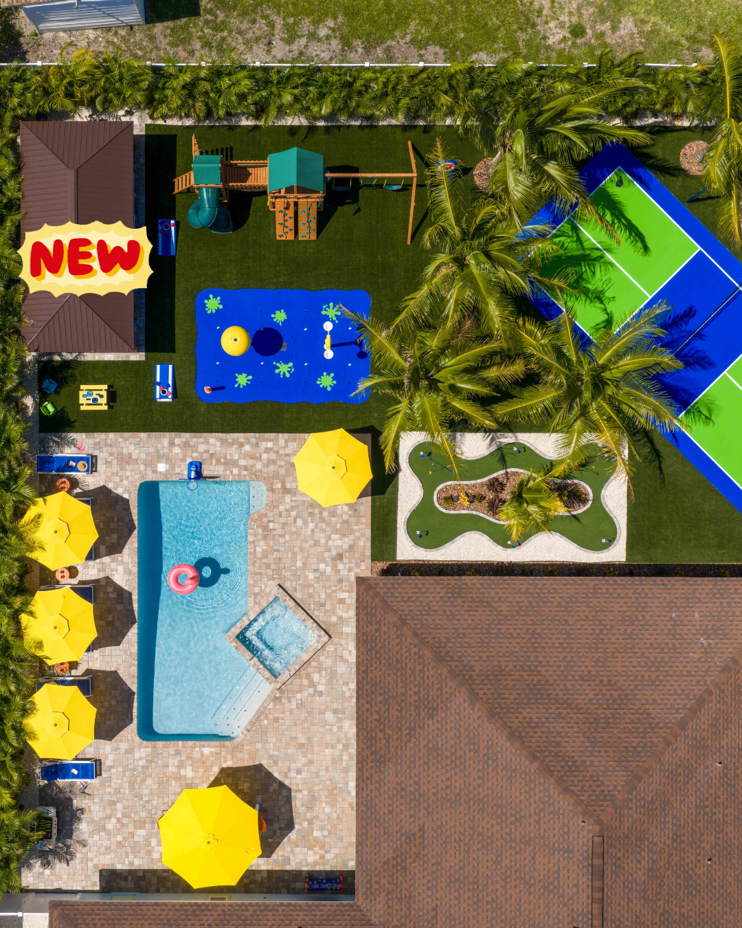 Aerial view of a luxurious backyard with pool, playground, and tennis court; yellow umbrellas and