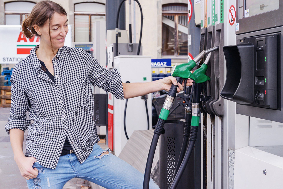 Une femme utilise une pompe à essence à la station vallée verte