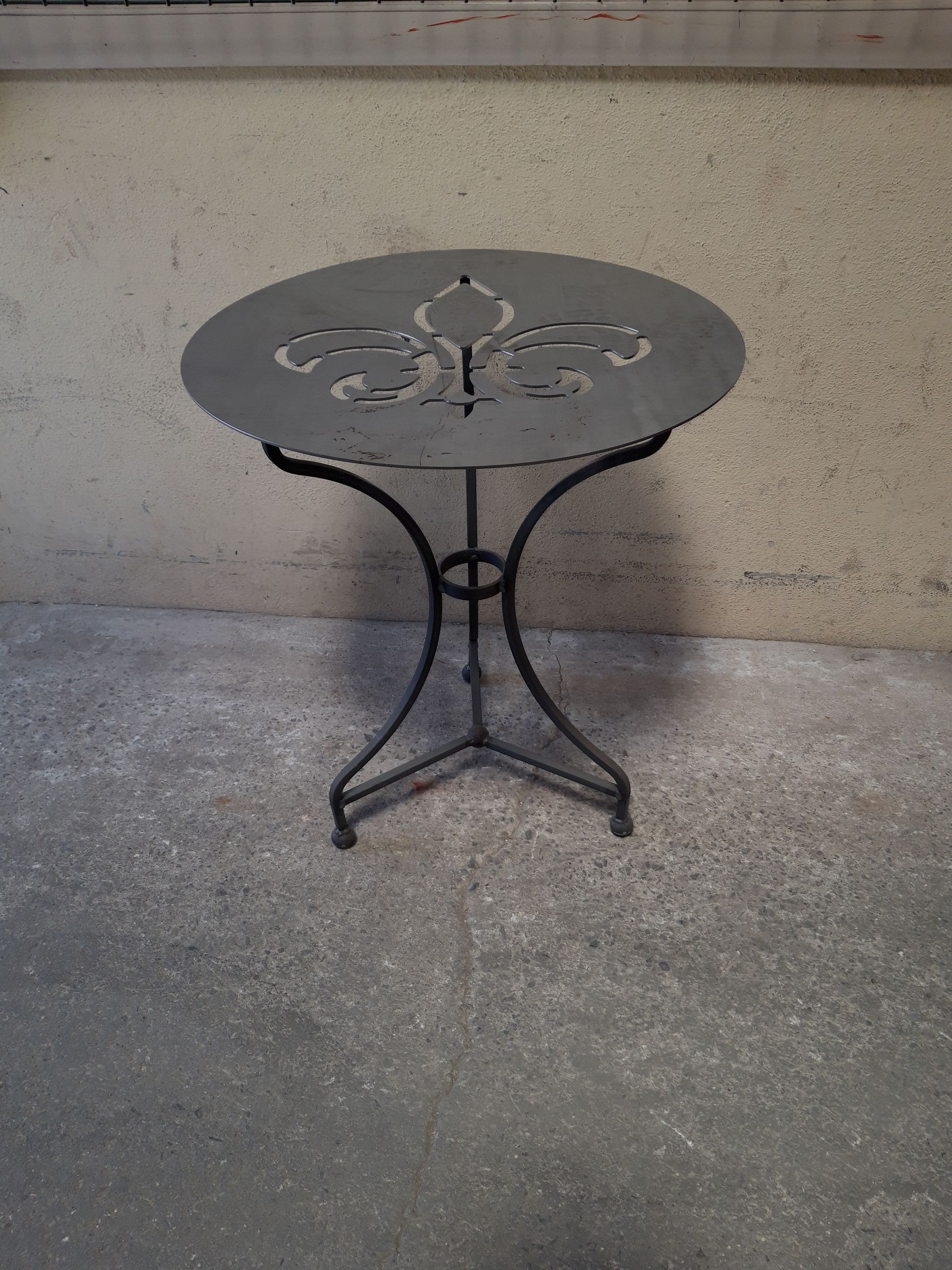 Table de jardin en métal sombre pour laquelel un décapage par bain doit être réalisé