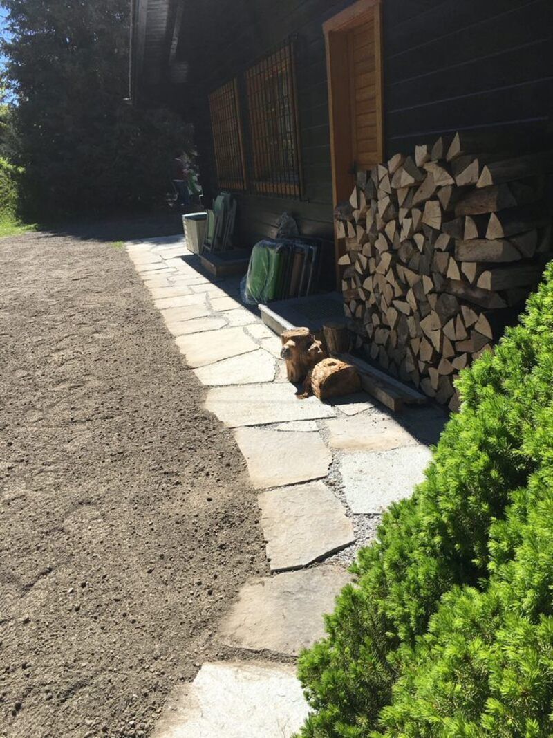 Un tas de bois se trouve à côté d'une passerelle en pierre.
