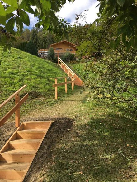 Un escalier en bois menant à une maison sur une colline.