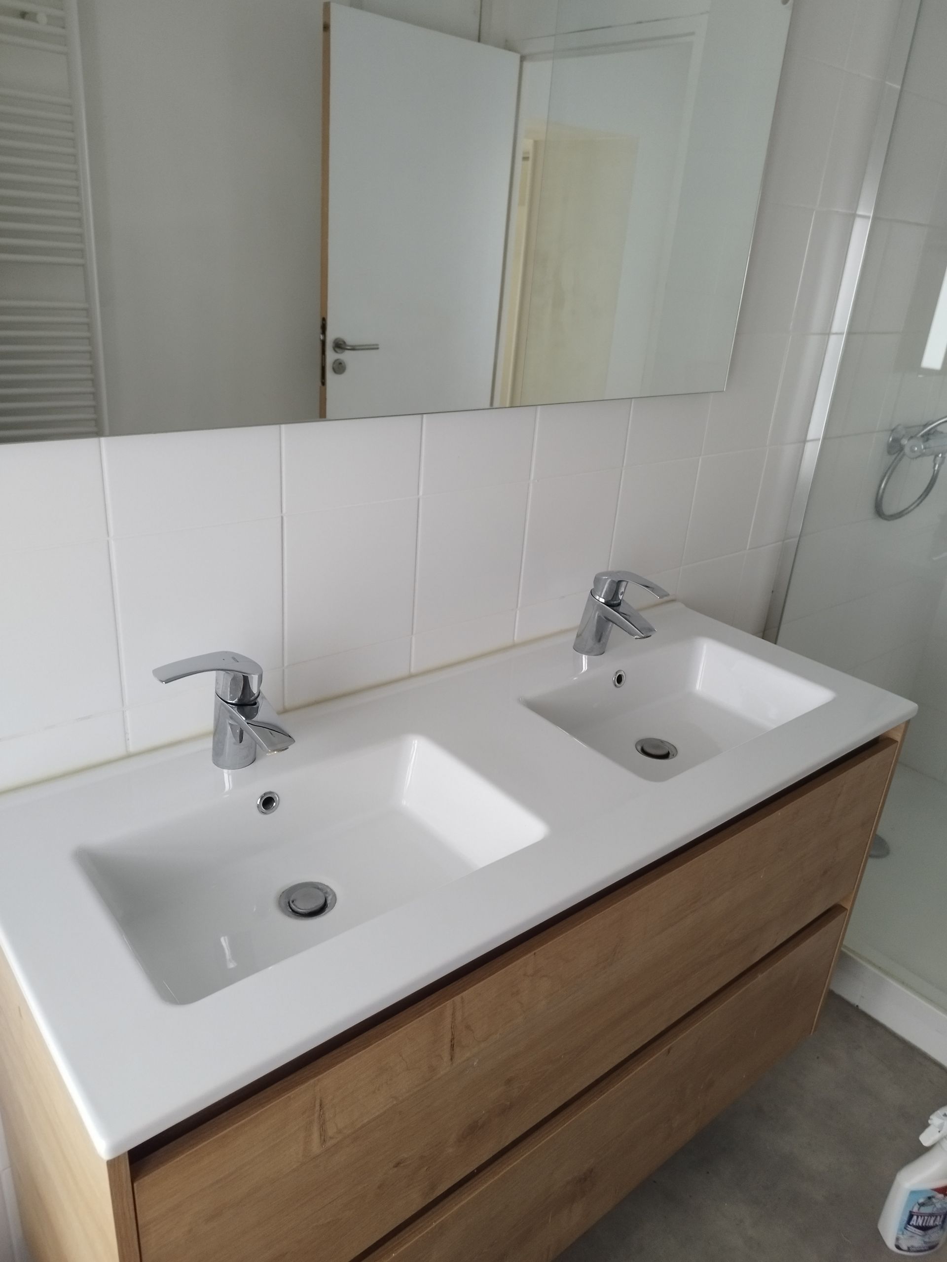 Un lavabo double blanc avec deux robinets argentés propre.