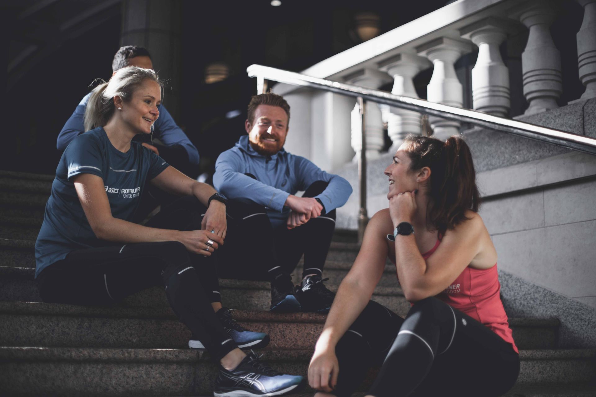 Eine Gruppe Leute sitzt auf einer Treppe und unterhält sich.
