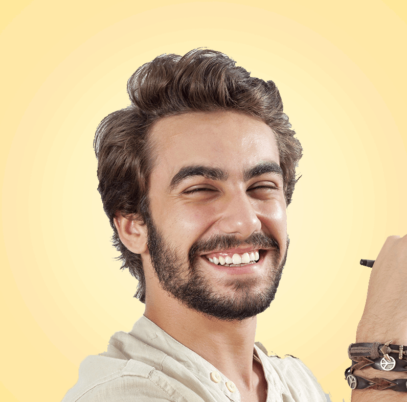 Ein lächelnder Mann hält einen Stift. Er hat dunkles Haar, einen Bart und trägt Armbänder.