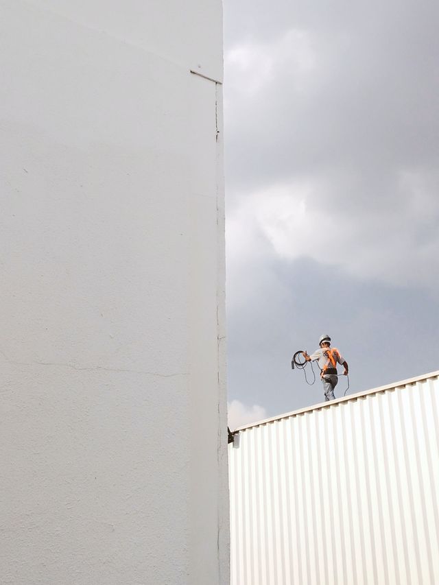 Un hombre está parado en el tejado de un edificio.