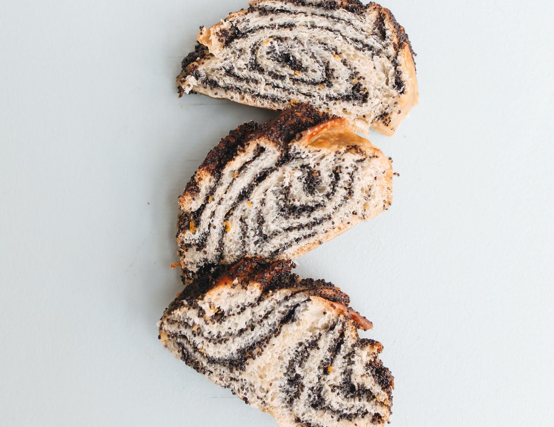 Trois tranches de pain sont empilées les unes sur les autres sur une surface blanche.