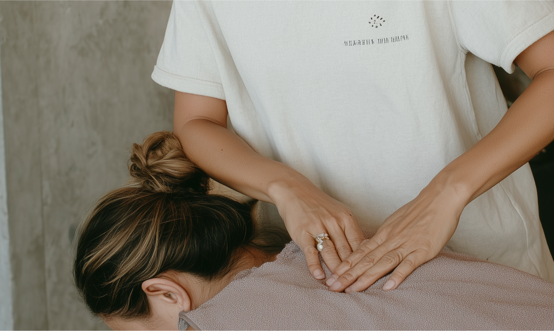Eine Person, die von einer Person in einem beigen Hemd eine Rückenmassage erhält.