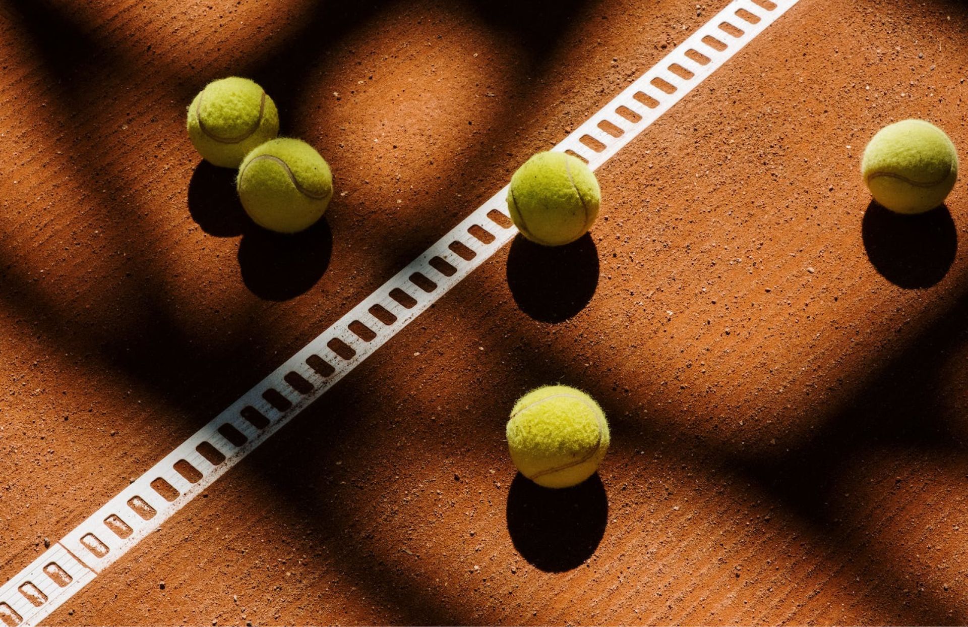 Tres pelotas de tenis están en una cancha de tenis