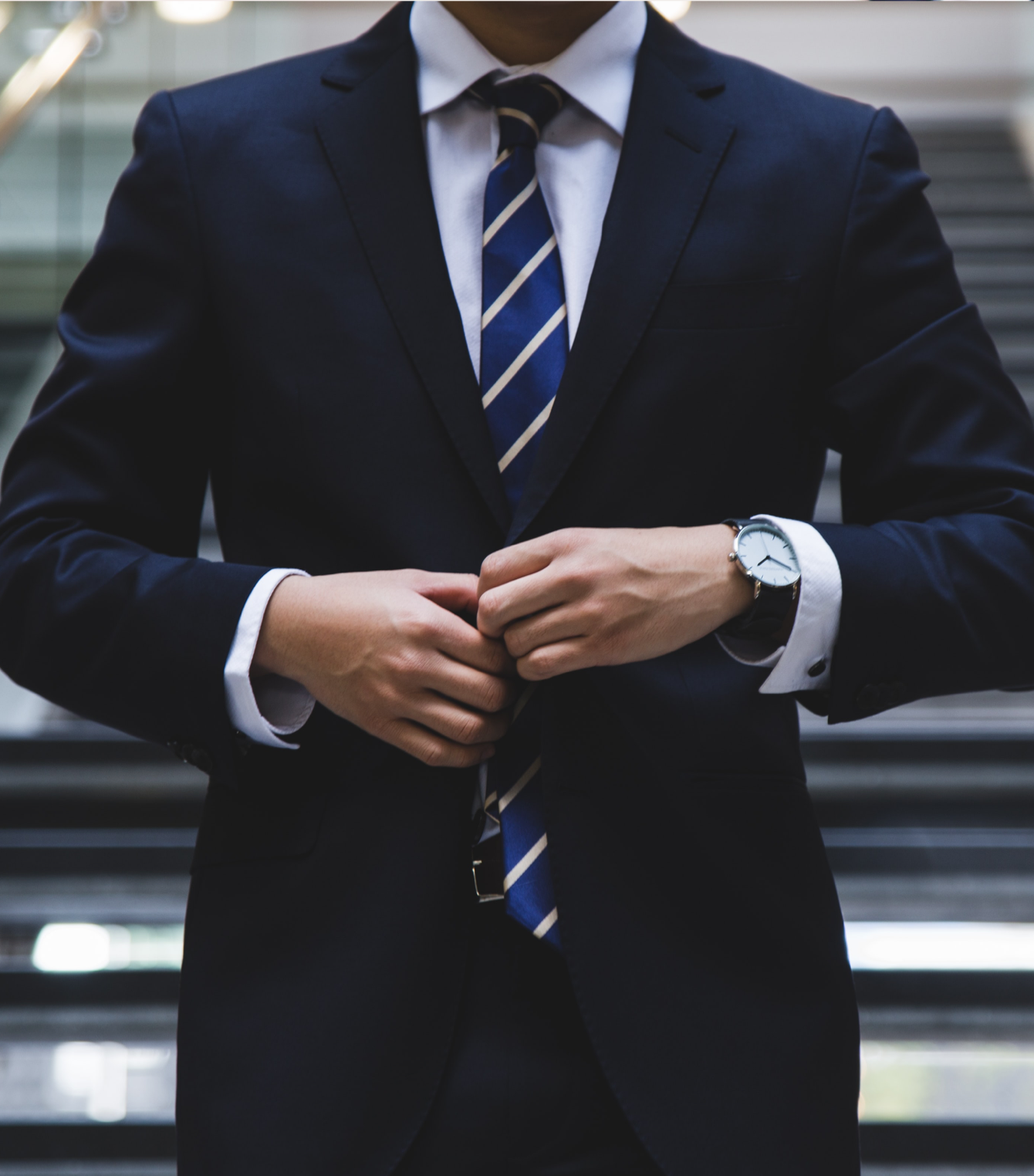 Un hombre con traje y corbata y un reloj en la muñeca.