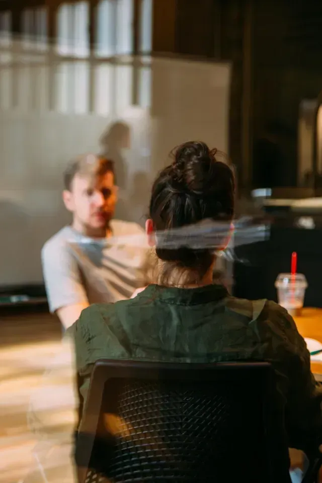 une femme de dos qui discute ave un homme qui lui fait face