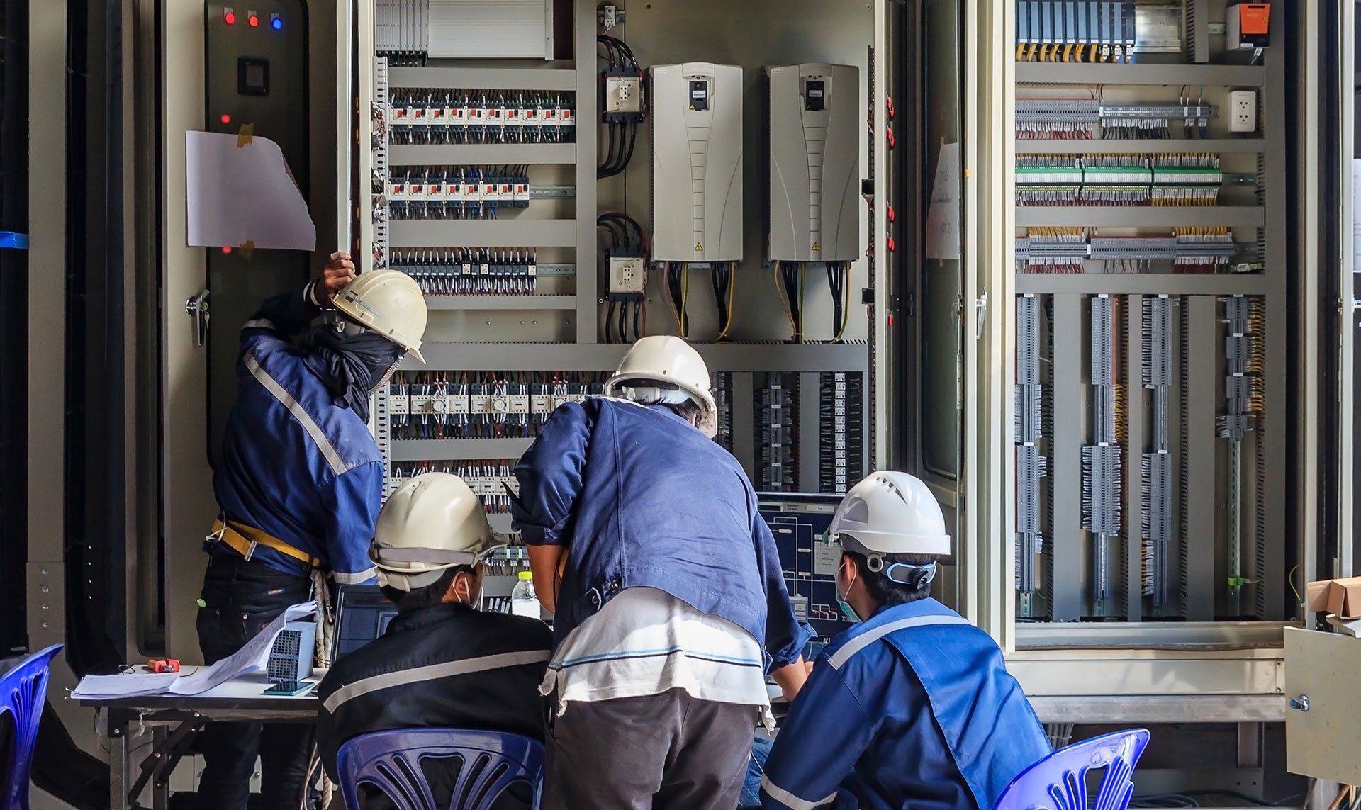 Un grupo de hombres está trabajando en una caja eléctrica.