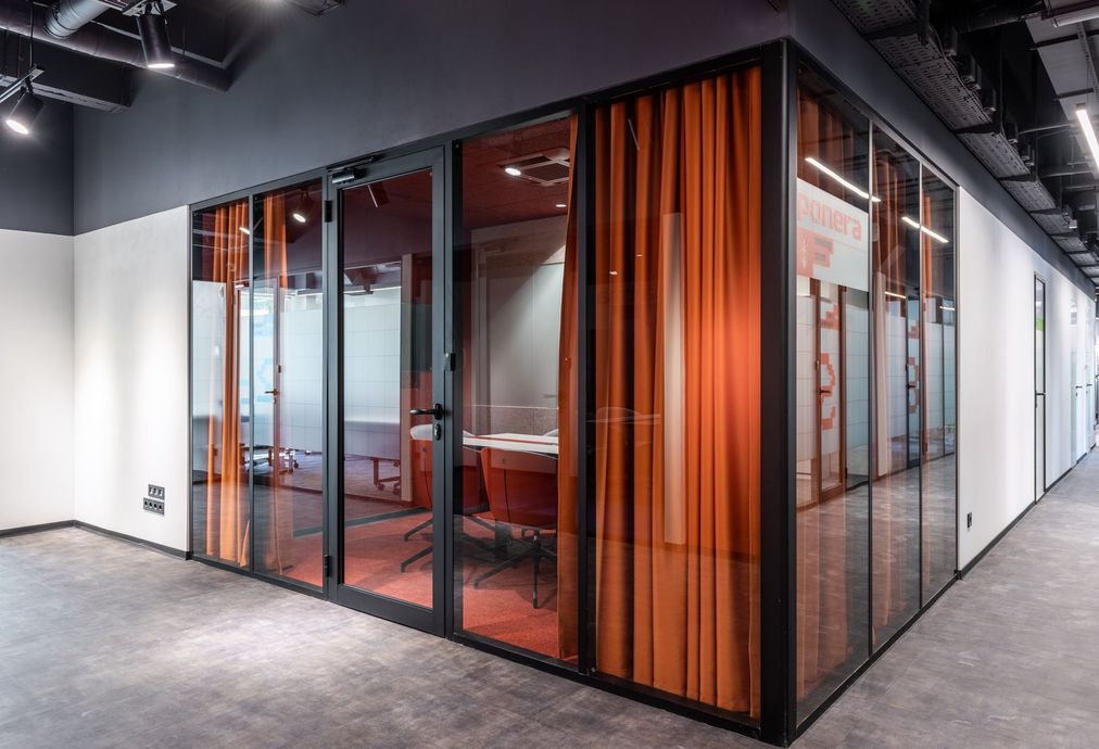 Una sala de conferencias con cortinas naranjas y una mesa en un edificio de oficinas.