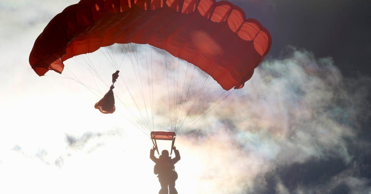 Eine Person fliegt mit einem roten Fallschirm durch die Luft.