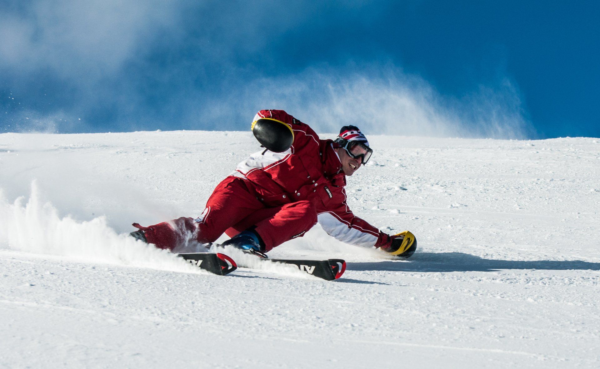 Eine Person fährt mit Skiern einen schneebedeckten Hang hinunter.