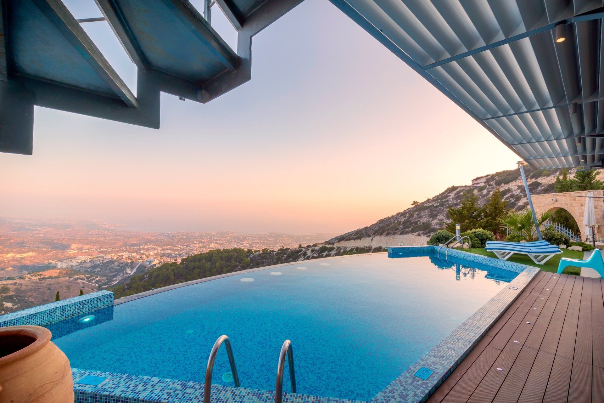 A large swimming pool with a view of a city and mountains.