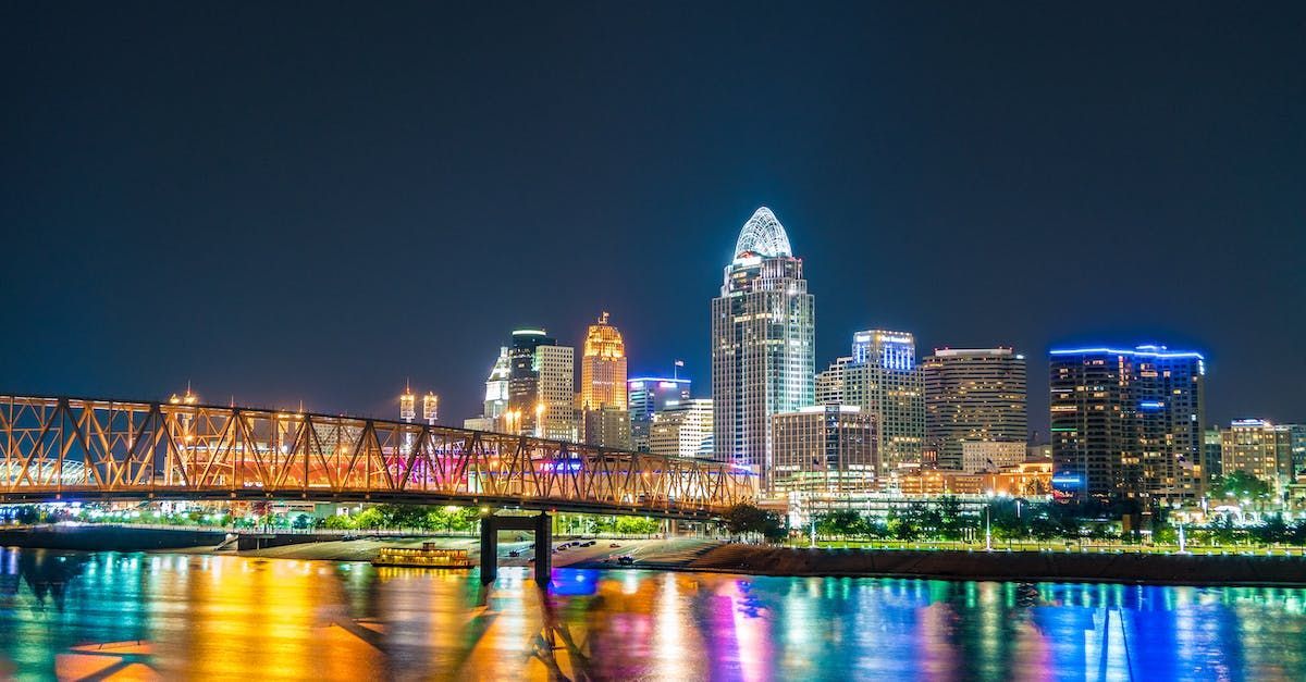 A city skyline at night with a bridge over a body of water.
