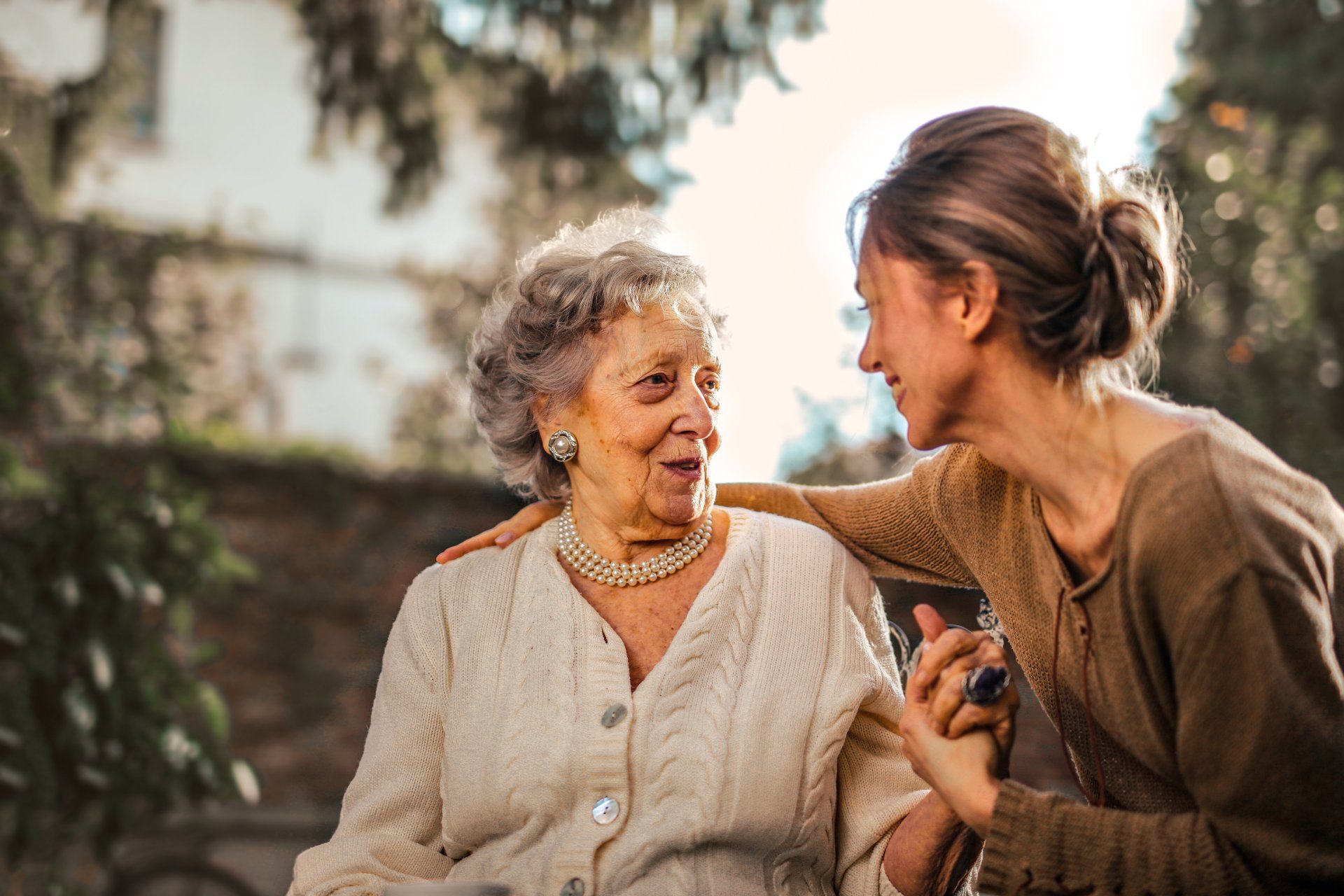 Seniorin im Garten mit Pflegerin