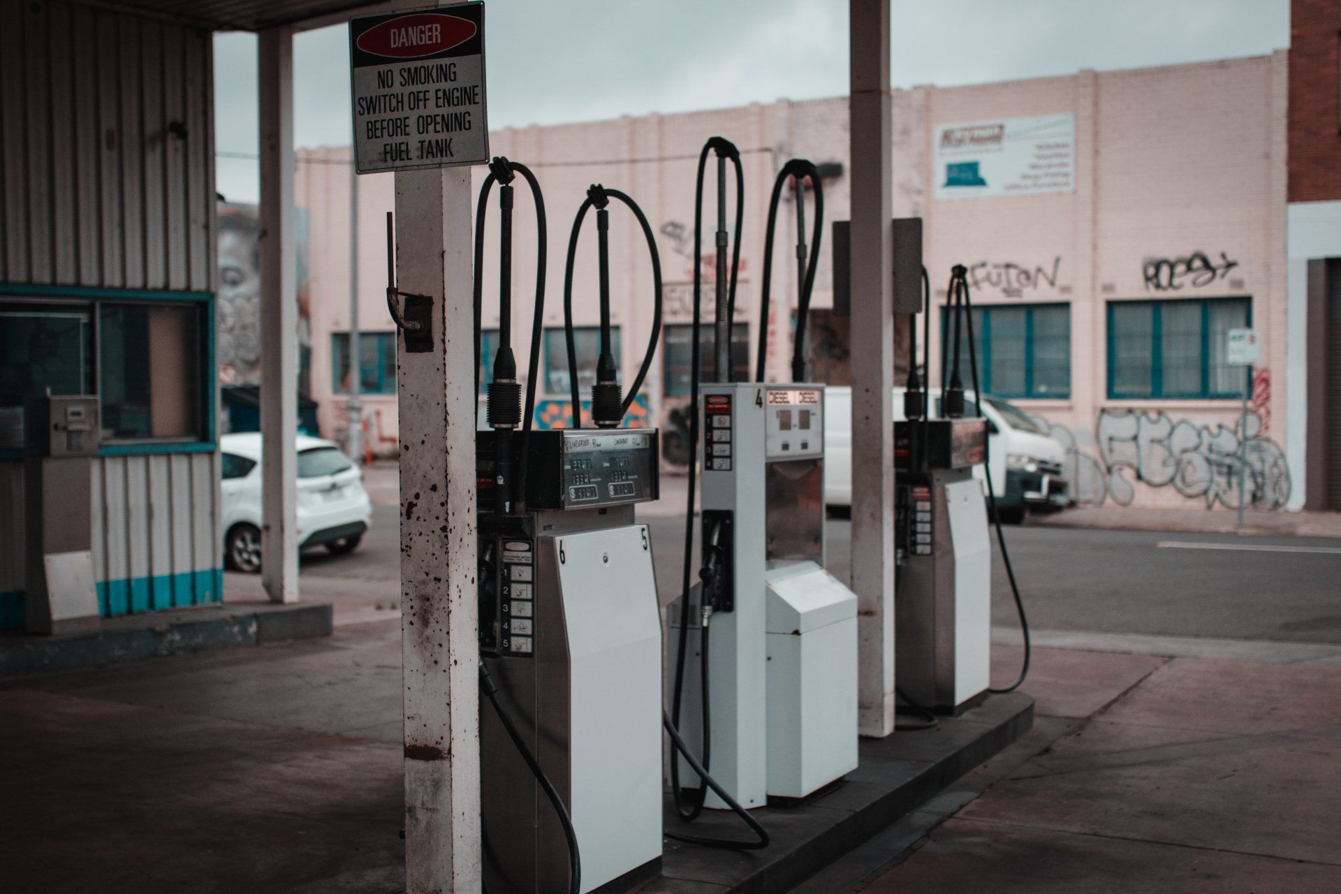 A gas station with a lot of pumps and a building in the background.