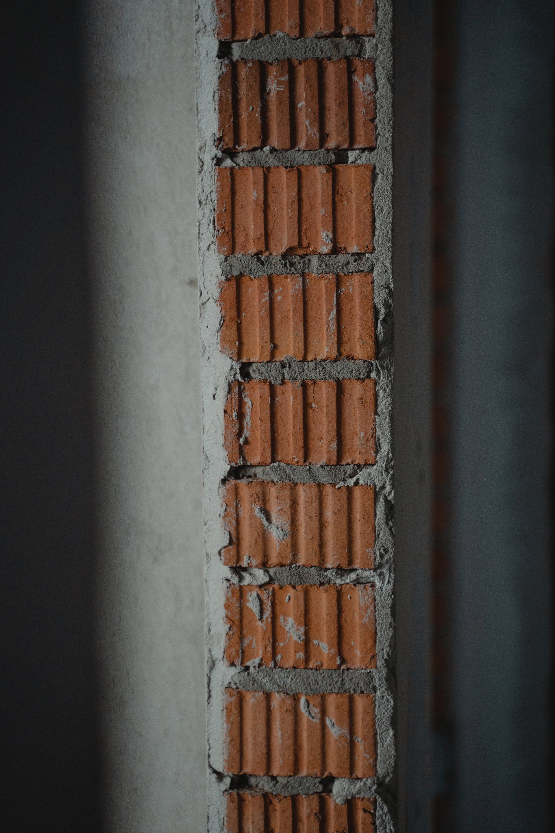 Un gros plan d'un mur de briques avec du béton entre les briques.