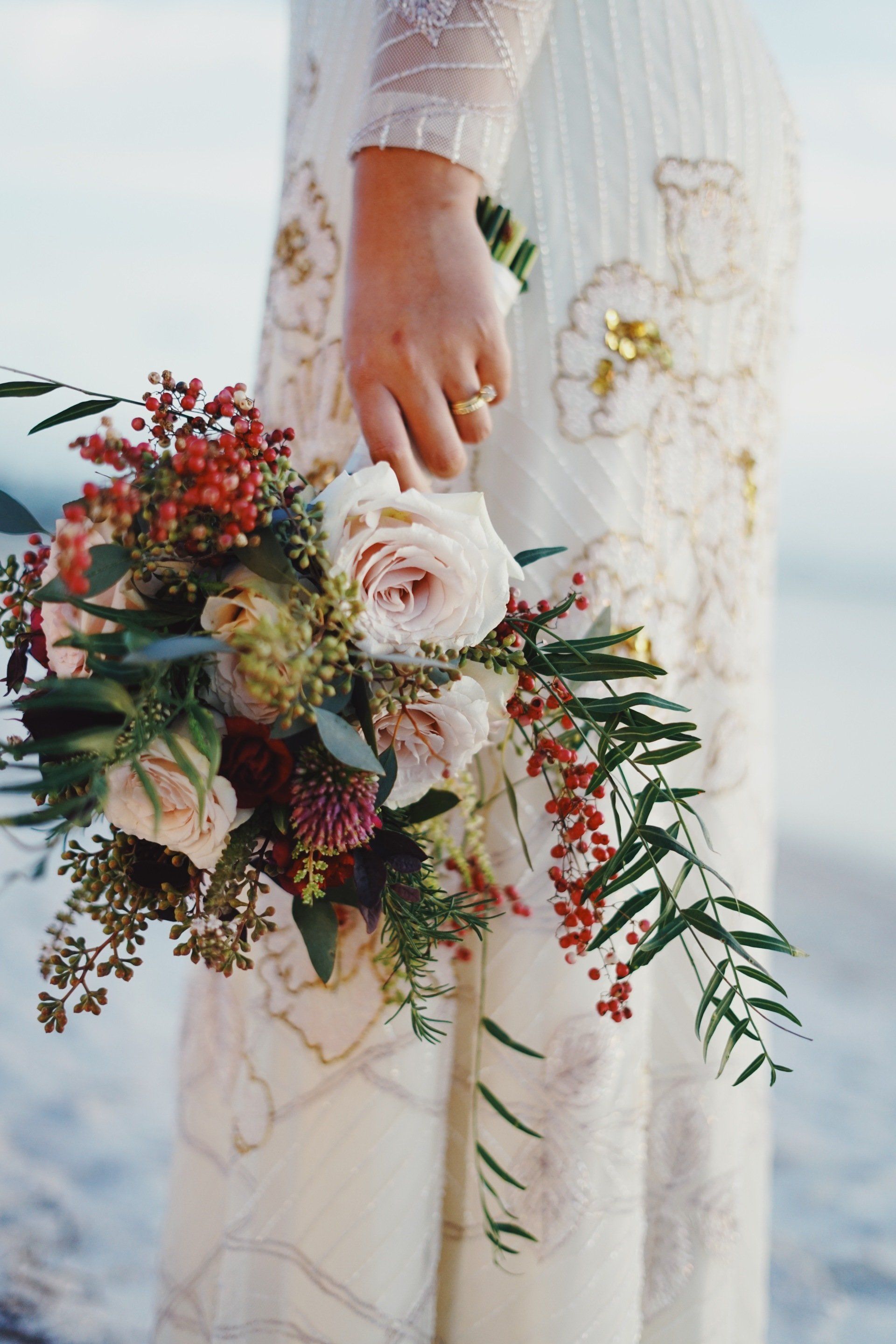Eine Frau in einem weißen Kleid hält einen Blumenstrauß