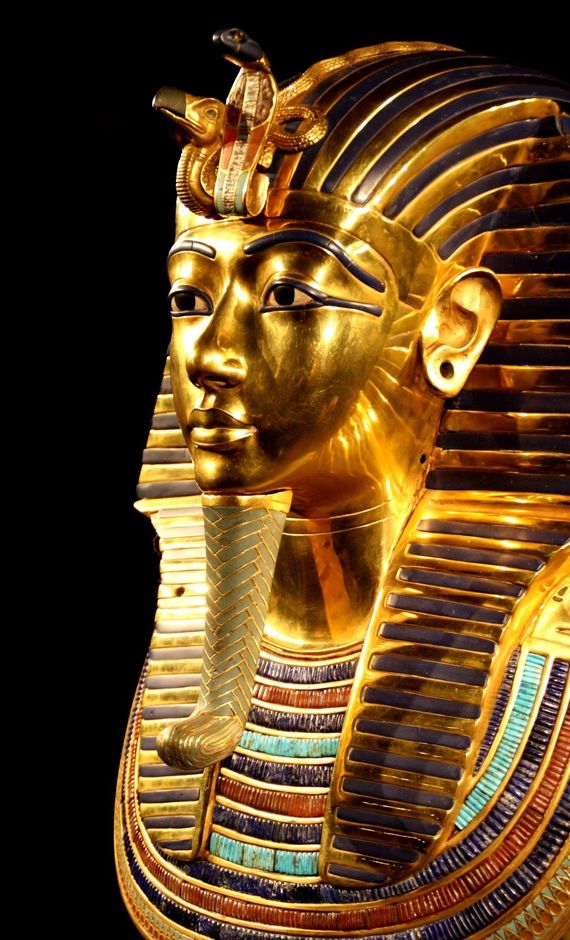 Close-up of the golden funerary mask of Tutankhamun, the Egyptian pharaoh. It features intricate details