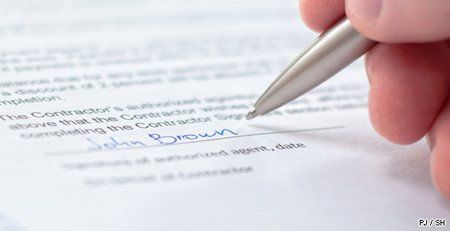 Une main tenant un stylo qui a signé un document