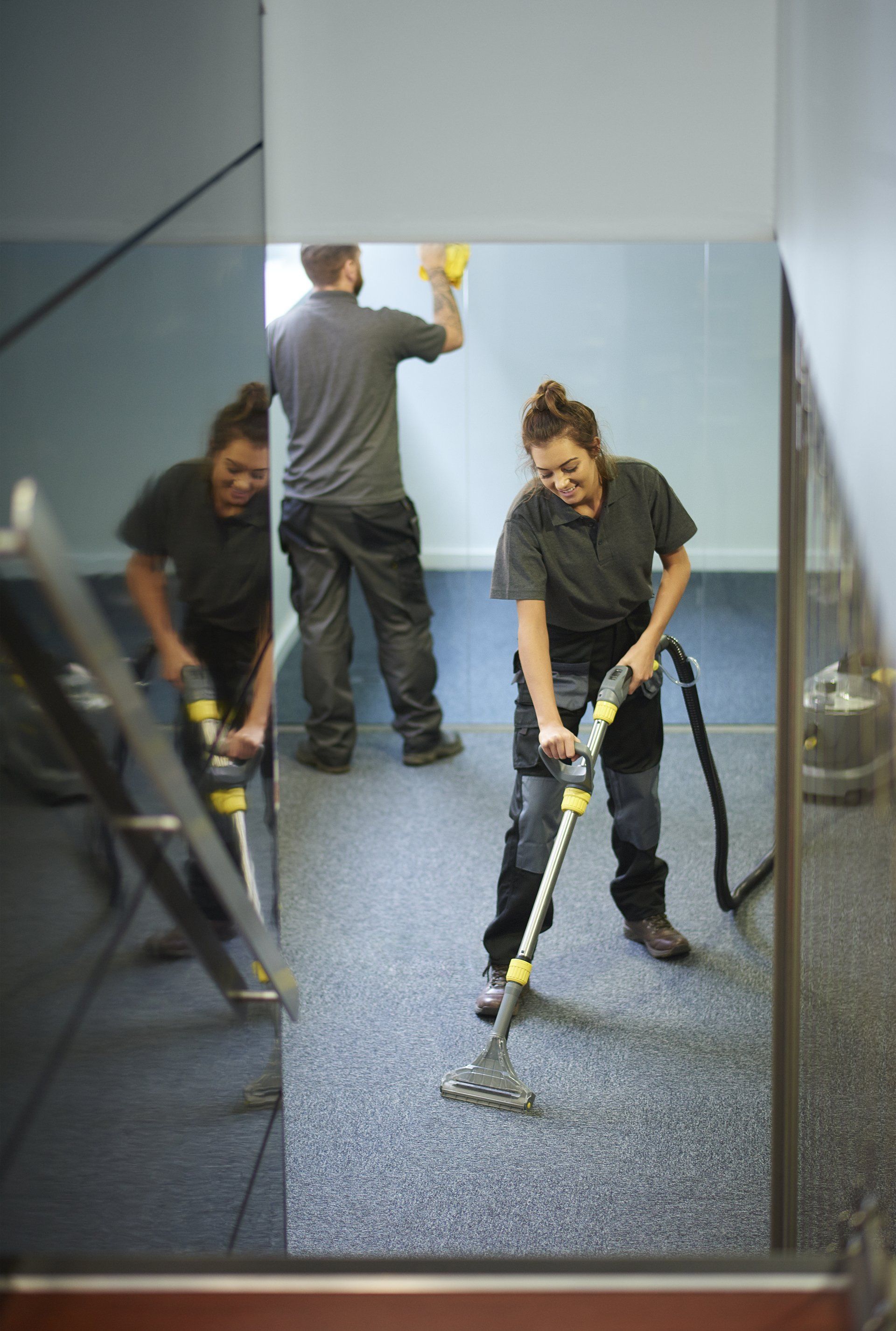 Deux personnes en train de nettoyage le sol et une personne un mur