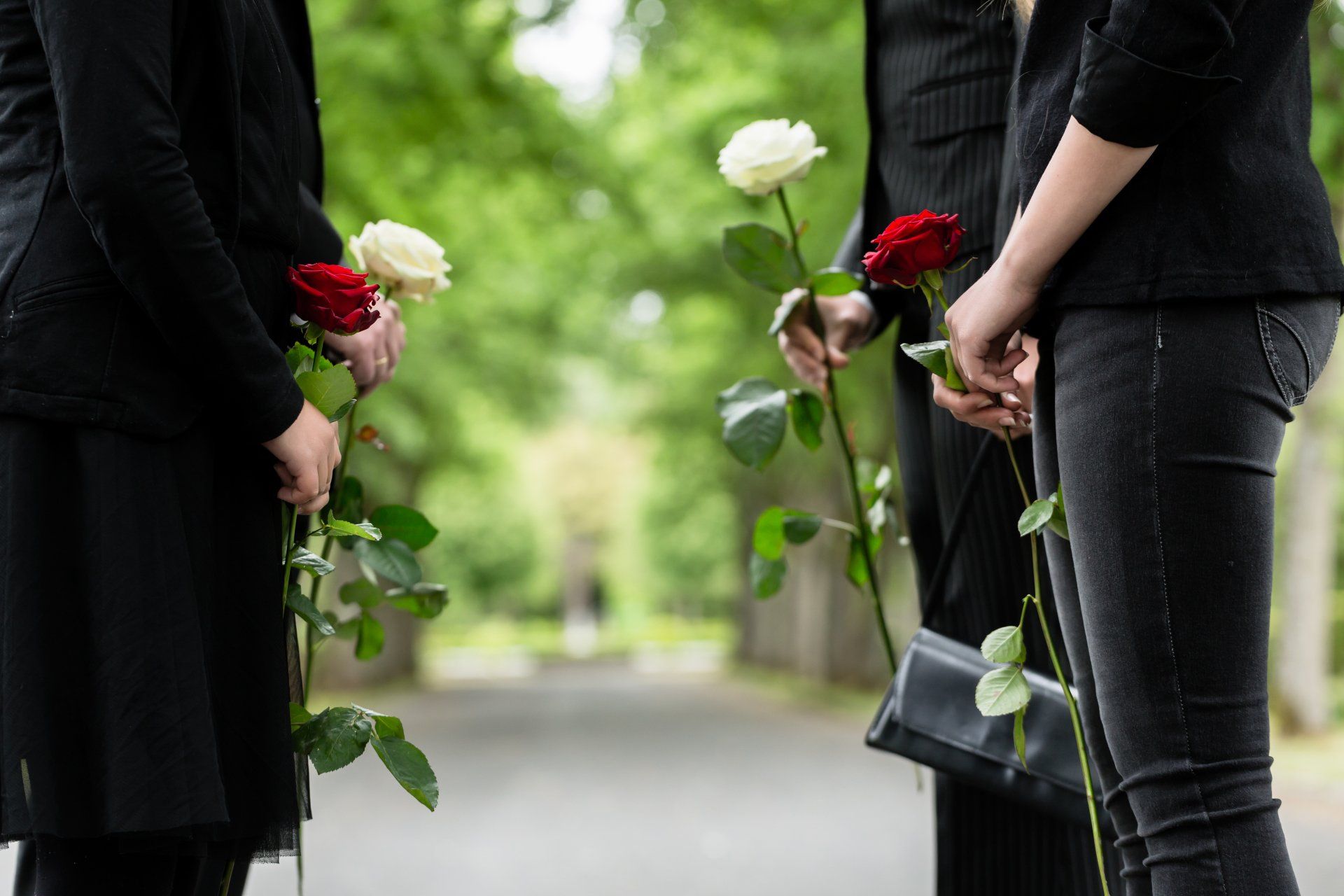 Photo de 4 personnes tenant des roses rouges et blanches dans les mains