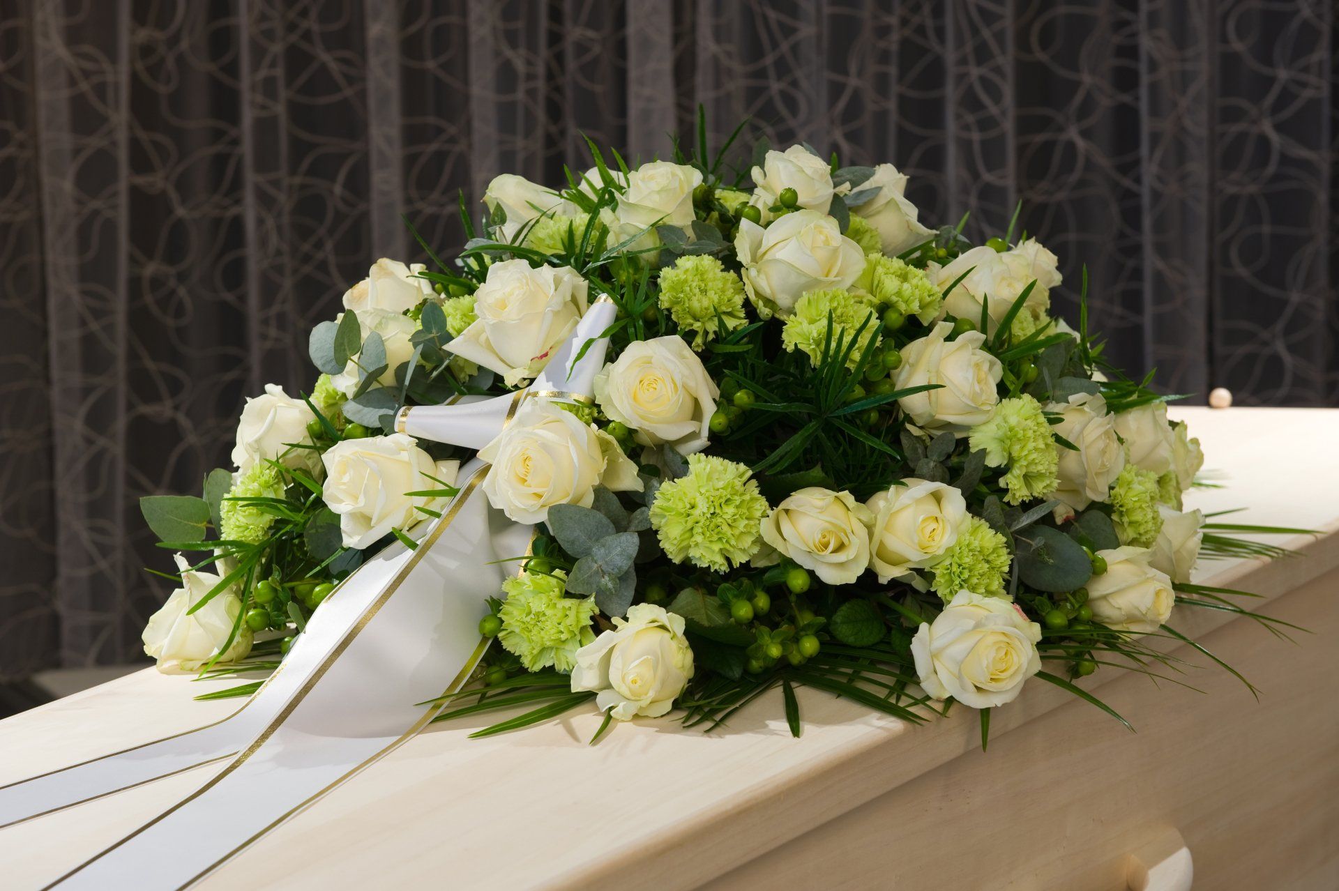 Photo d'un bouquet de fleurs blanches déposés sur un cercueil blanc