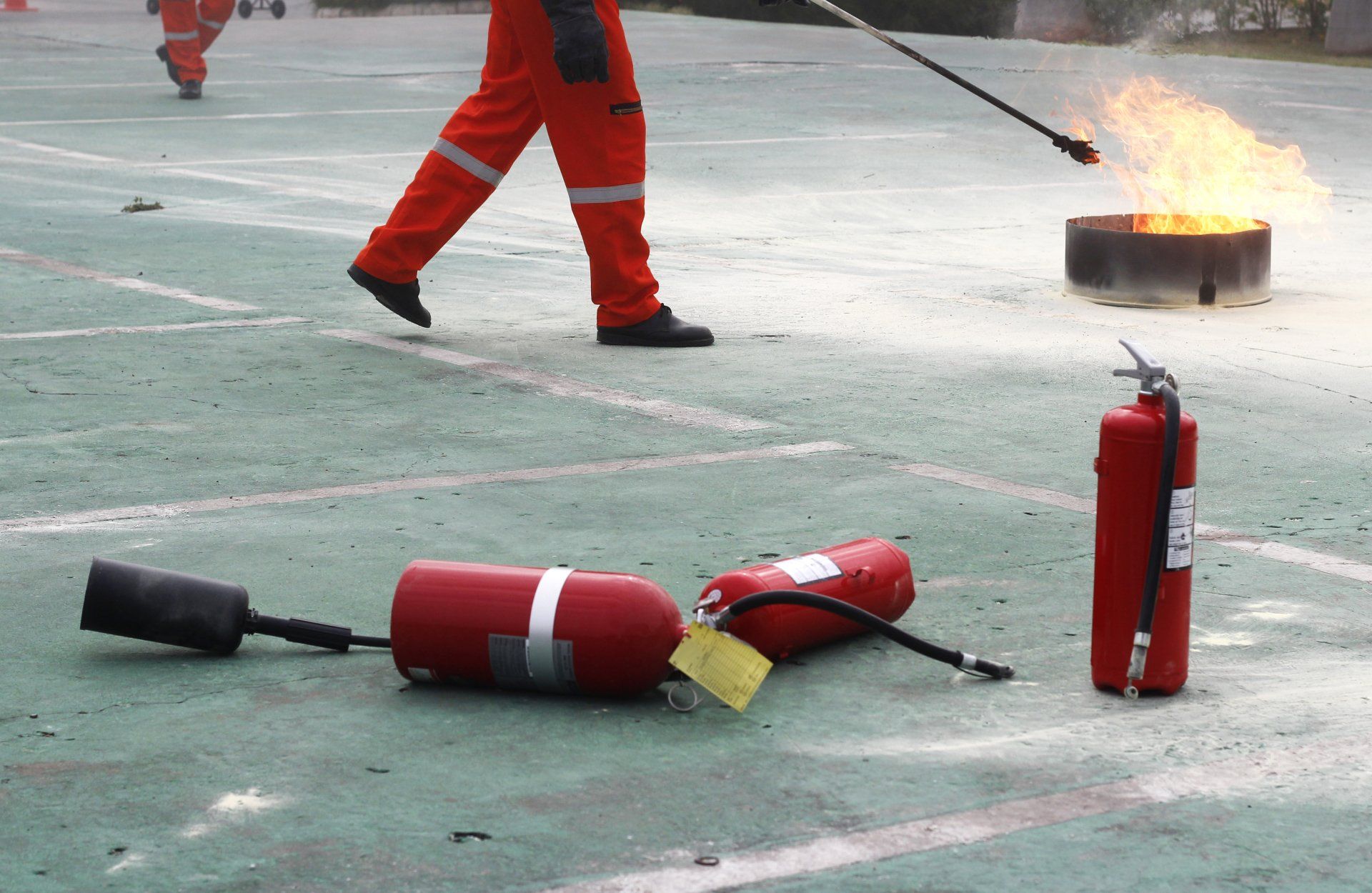 Formation à la sécurité incendie : une personne en combinaison utilise un extincteur.