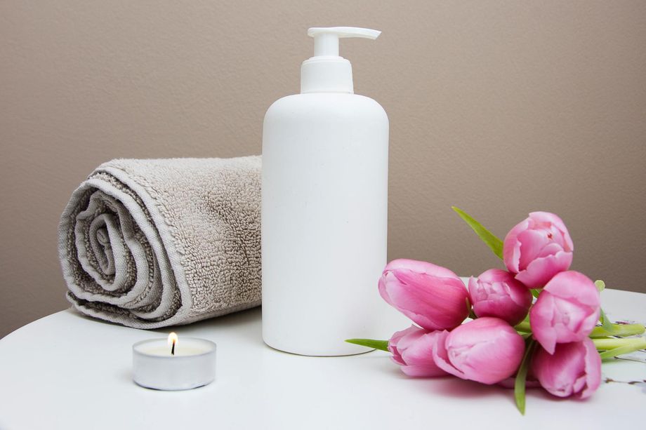 Serviette avec produit de massage (non contractuel) et tulipes.
